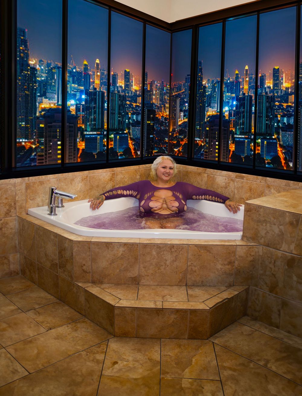 Woman relaxing in a corner jacuzzi bathtub with purple water, overlooking a stunning city skyline at night.