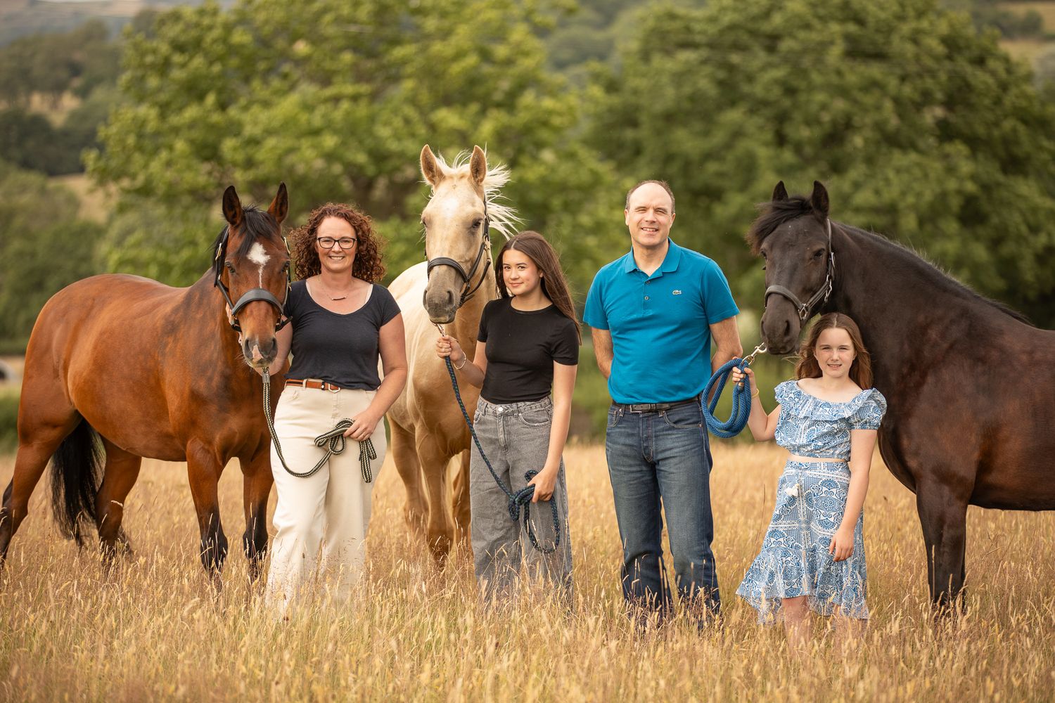A horse and its rider enjoy an outdoor photoshoot session near rustic wooden fencing on a sunny day.