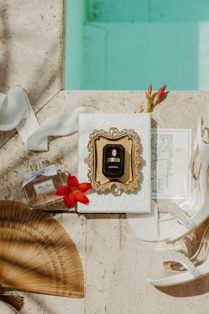 Vintage-style framed photo with red flowers and a decorative fan on white surface.