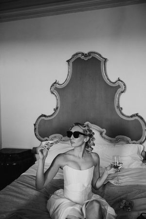 Black and white photo of bedroom with ornate headboard and elegant decor.