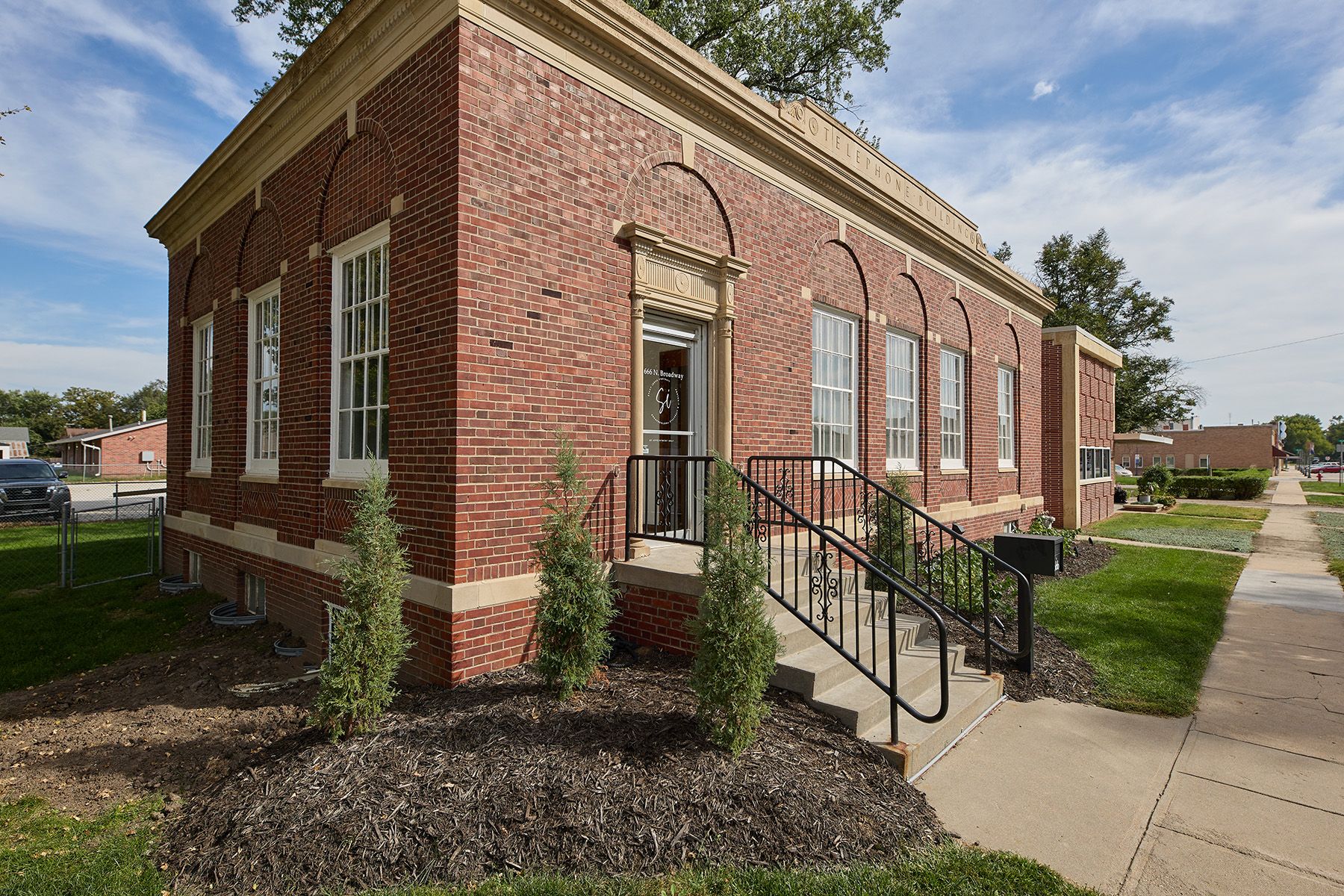 Historic red brick building with arched windows and black metal railings.