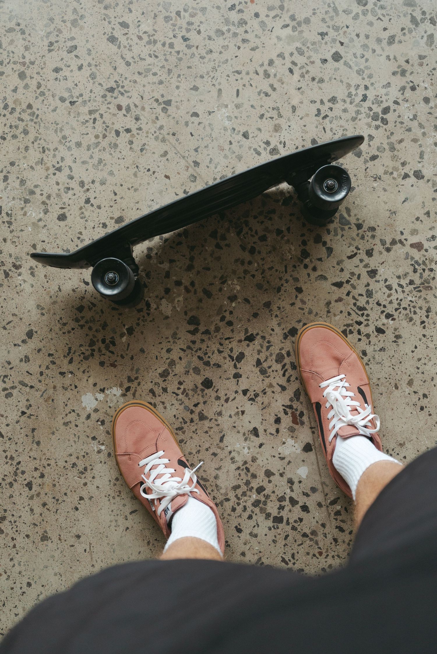 A sequence of skateboarding images showing brown leather shoes pushing off the ground next to a black skateboard.