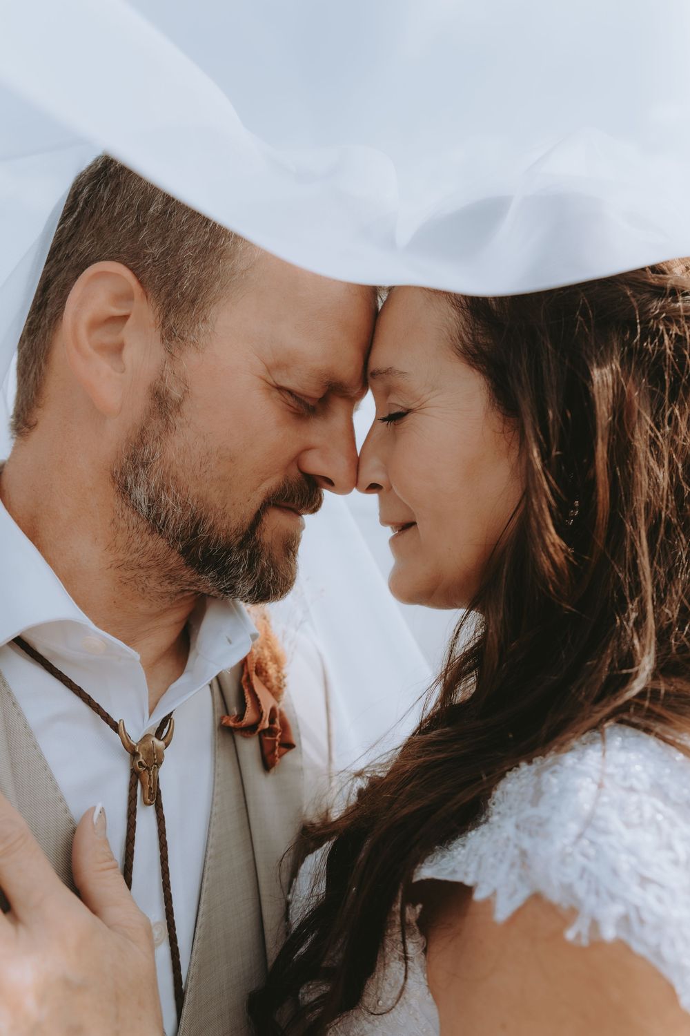 Romantic close-up photos of a couple in wedding attire sharing intimate moments under soft lighting.