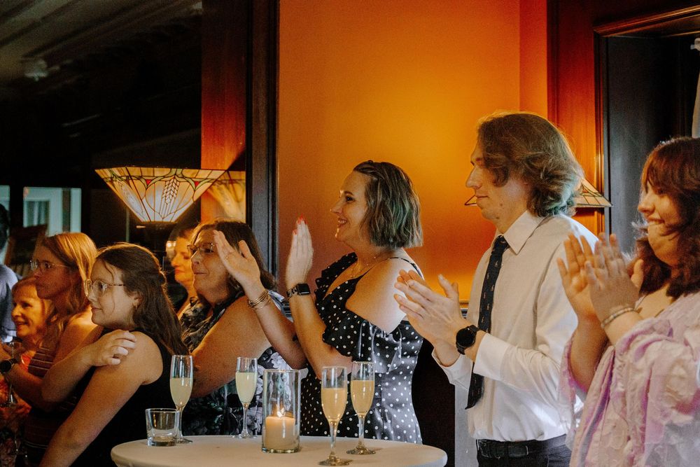 People gathered at restaurant tables with warm lighting creating an intimate dining atmosphere.