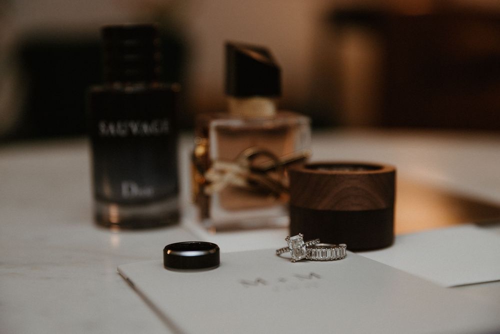 Minimalist wedding stationery and accessories arranged on light surface with dark accents.