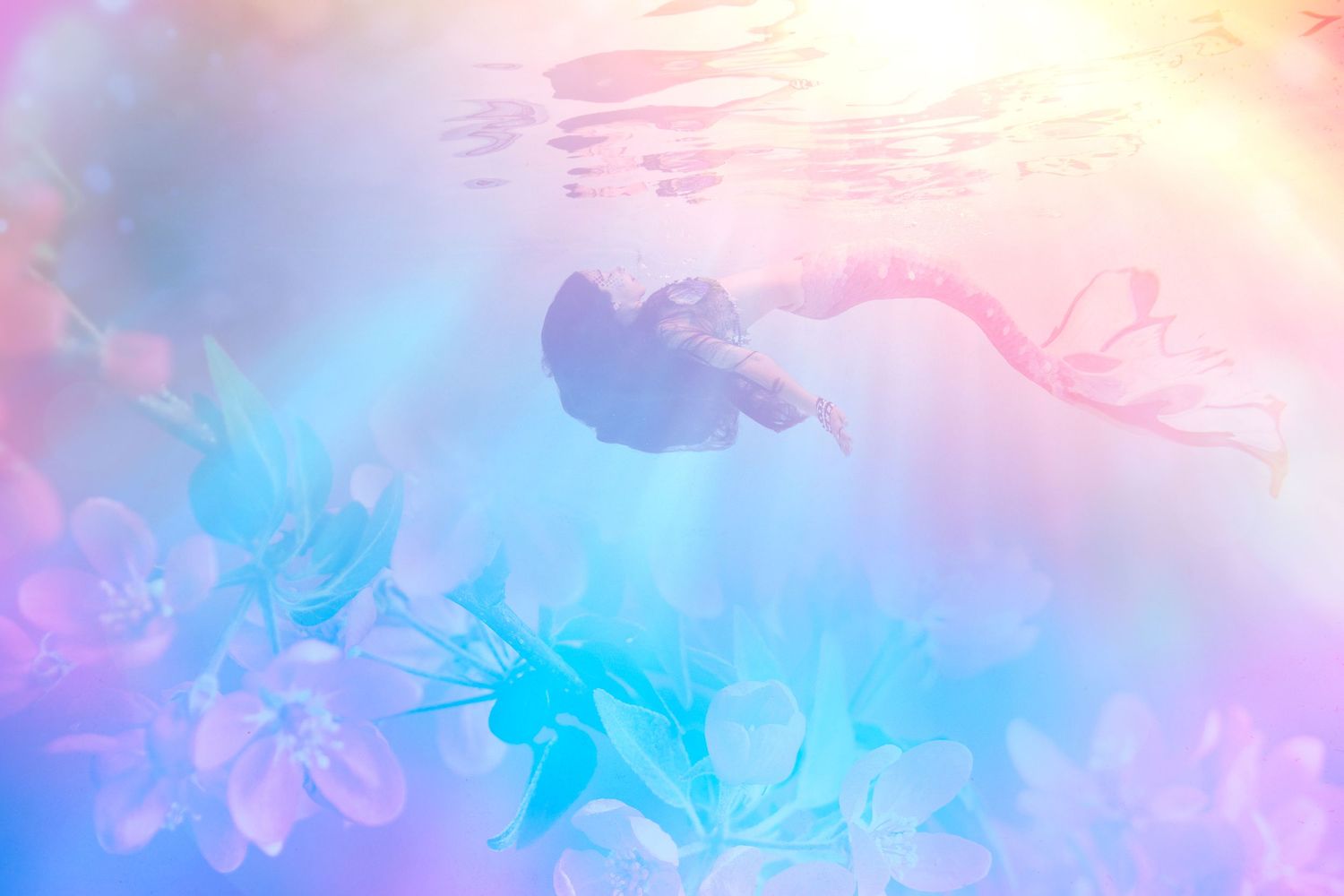 Abstract pink and blue watercolor background with dreamy pastel gradient effects and a mermaid floating close to the surface.