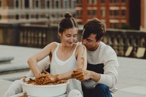 Romantic rooftop date scene with snacks on a small white table against city architecture.