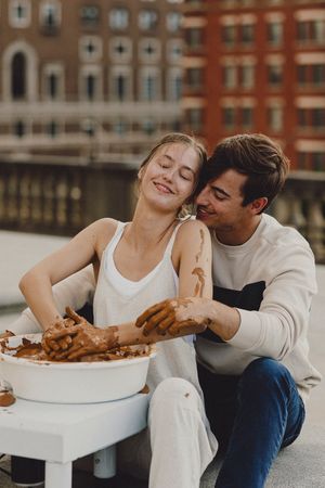 Intimate moment captured on an urban rooftop with classic brick buildings in the background.