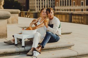Urban rooftop scene with two people sharing intimate moments against classic architecture.