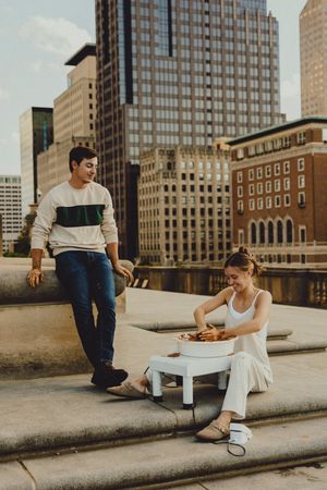 A pottery making session takes place on a city rooftop with modern buildings in the background.
