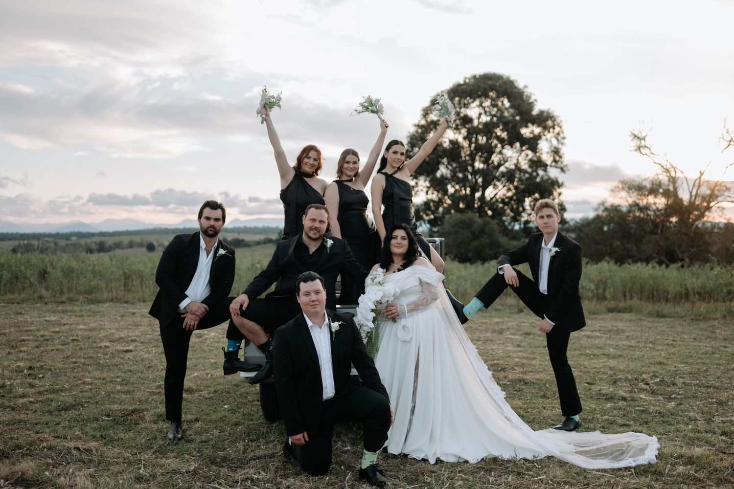 Wedding party in formal attire jumps joyfully in unison across a series of candid outdoor photos at sunset.