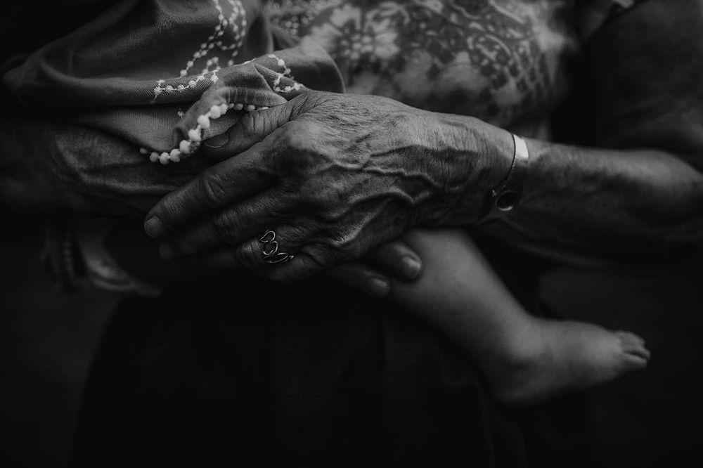 Black and white portrait of grandmother holding grandchild.
