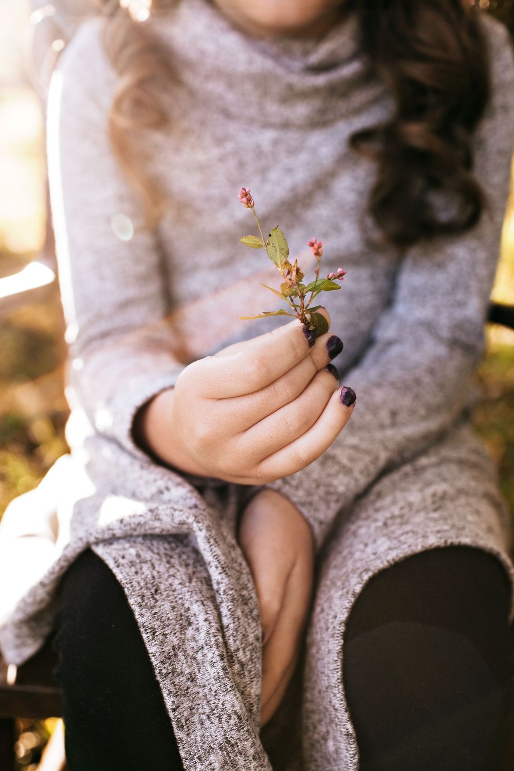 Child portrait holding flower during golden hour.