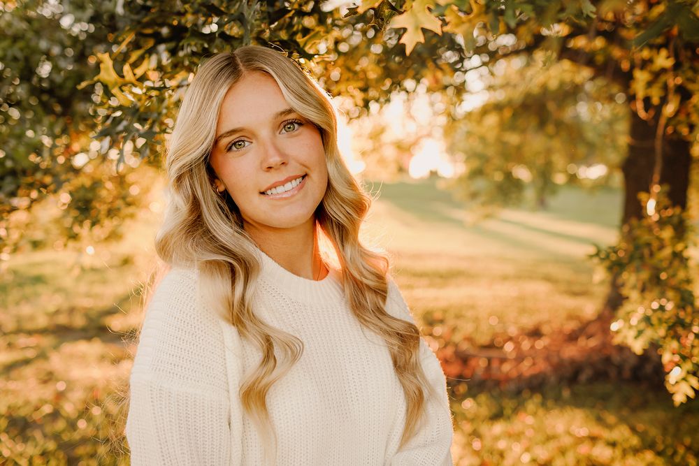Teenage girl in white sweater with fall background in Springfield MO