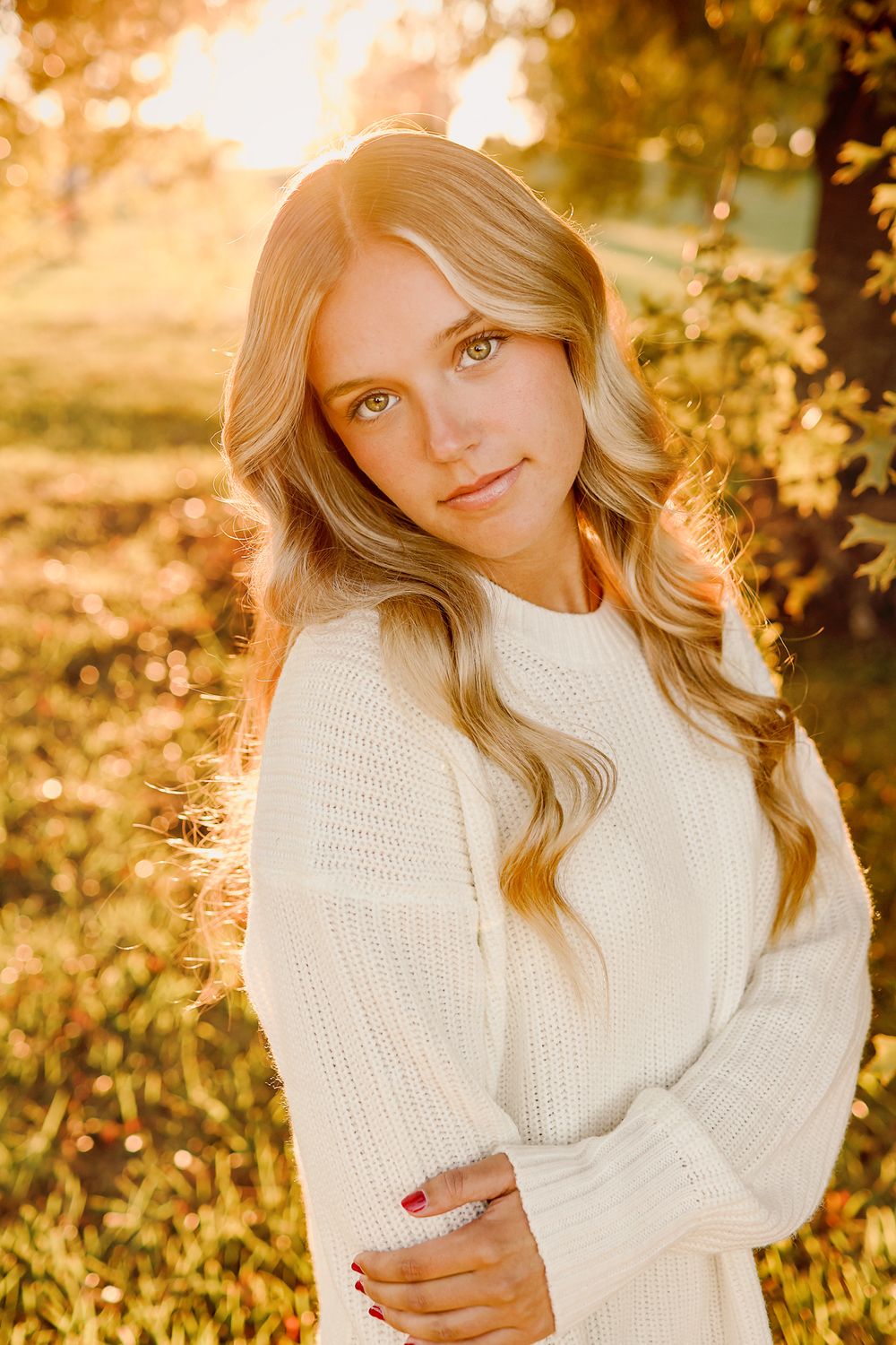 Teenage girl in white sweater with golden hour behind her in Springfield MO