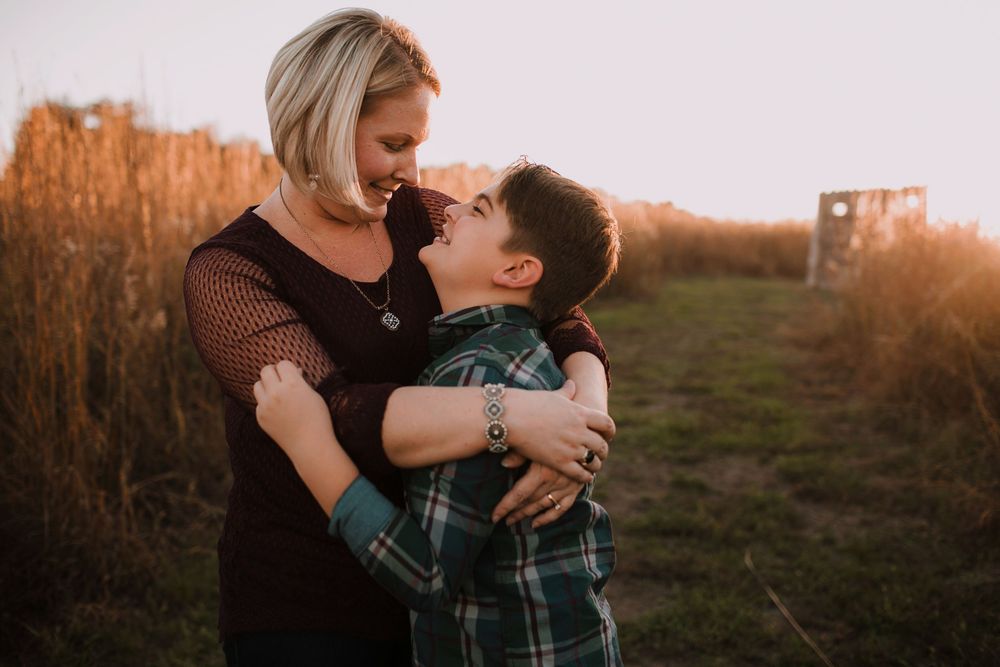 Mother and son during golden hour in open field.