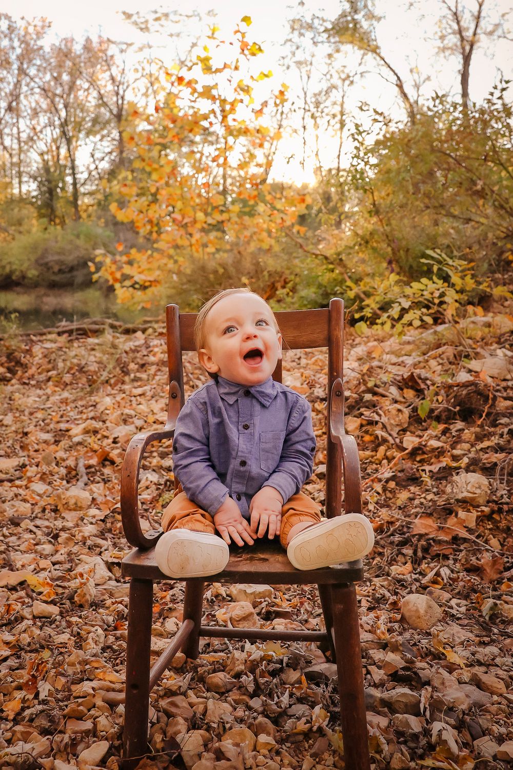Little boy sitting in antique chair with fall background in Springfield MO