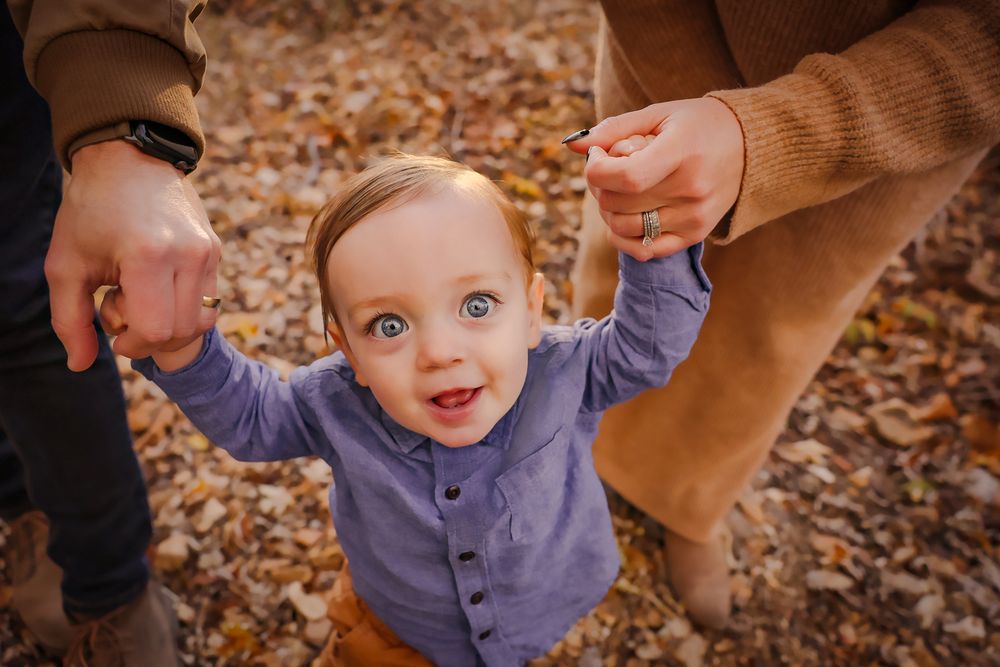 Little boy holding hands with parents in Springfield MO
