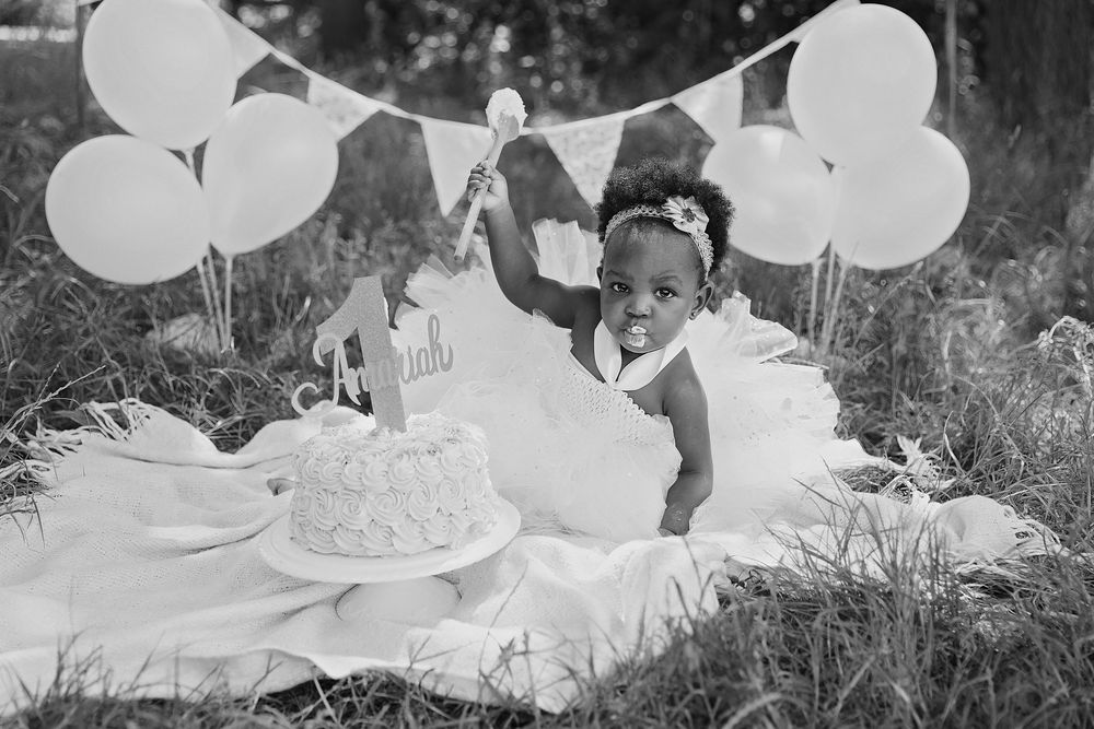 Black and white party scene with balloons and cake decorations showing a festive celebration atmosphere.