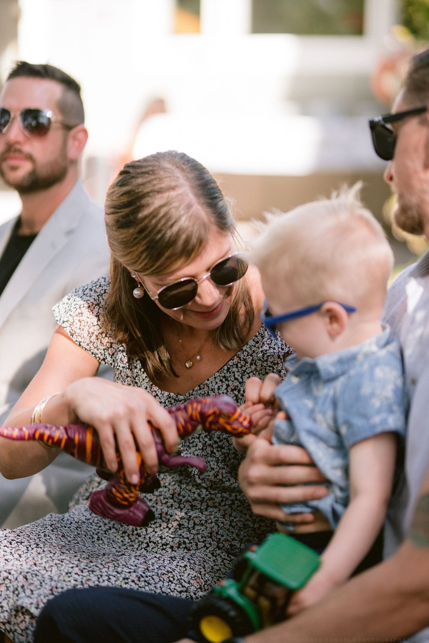 People enjoying a casual outdoor gathering wearing sunglasses and summer attire.