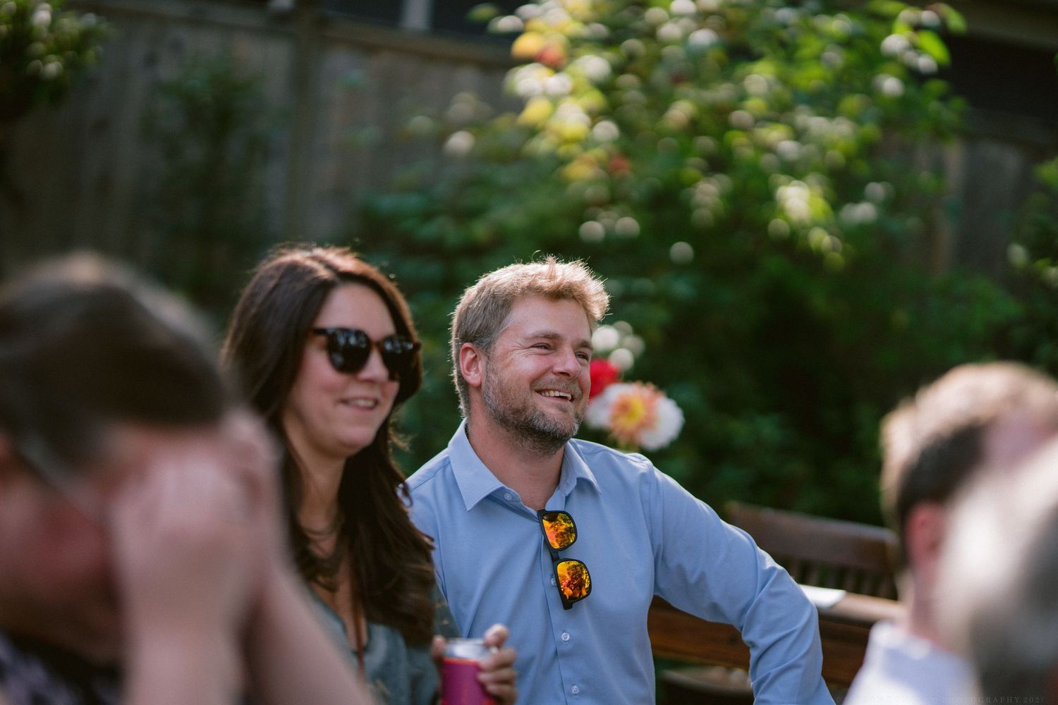 A group of guests enjoying drinks and conversation at an outdoor garden party.