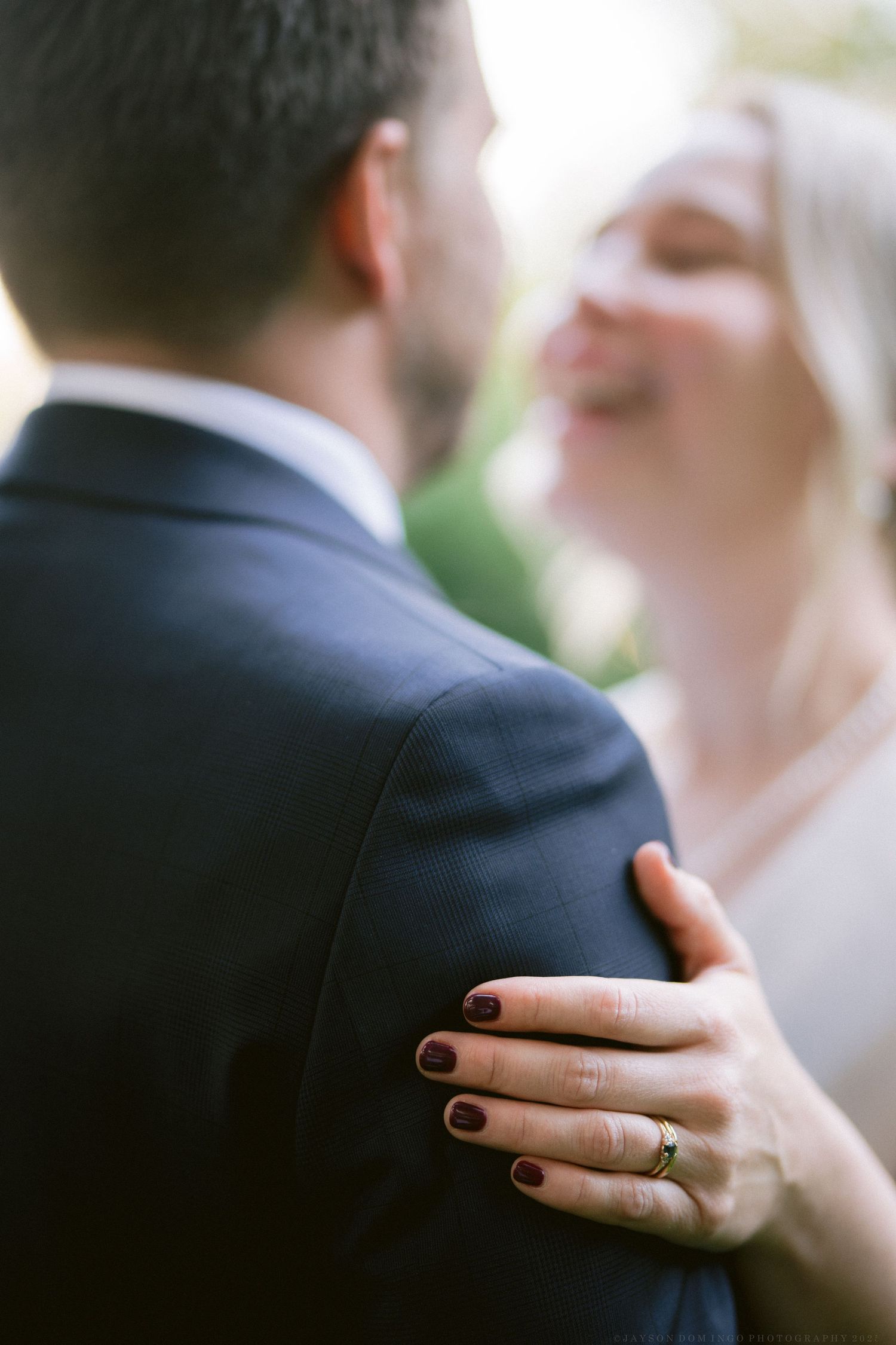 Close-up of wedding rings and hands embracing during an intimate moment.