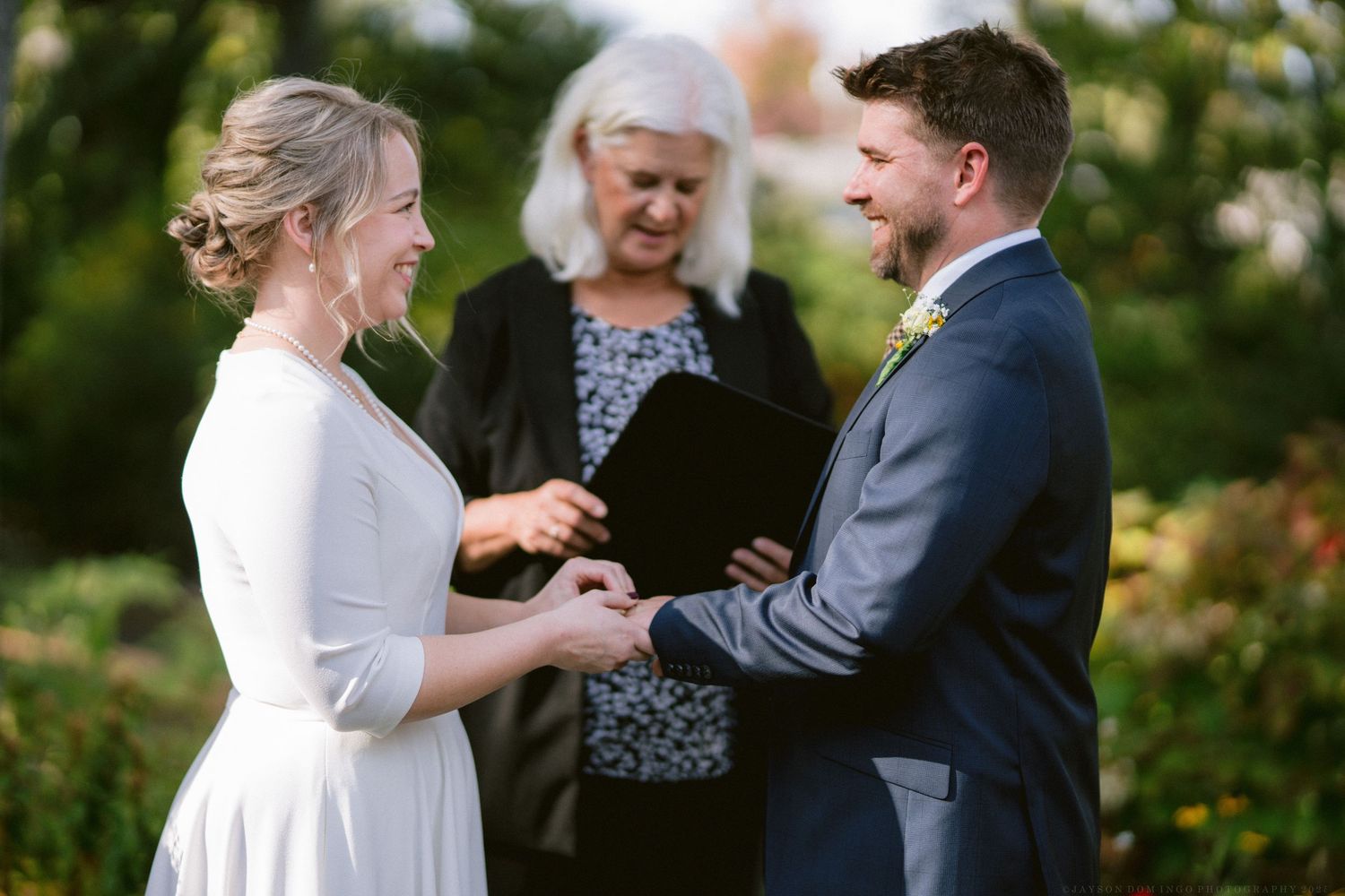 A joyful outdoor wedding ceremony moment captured in a garden setting.