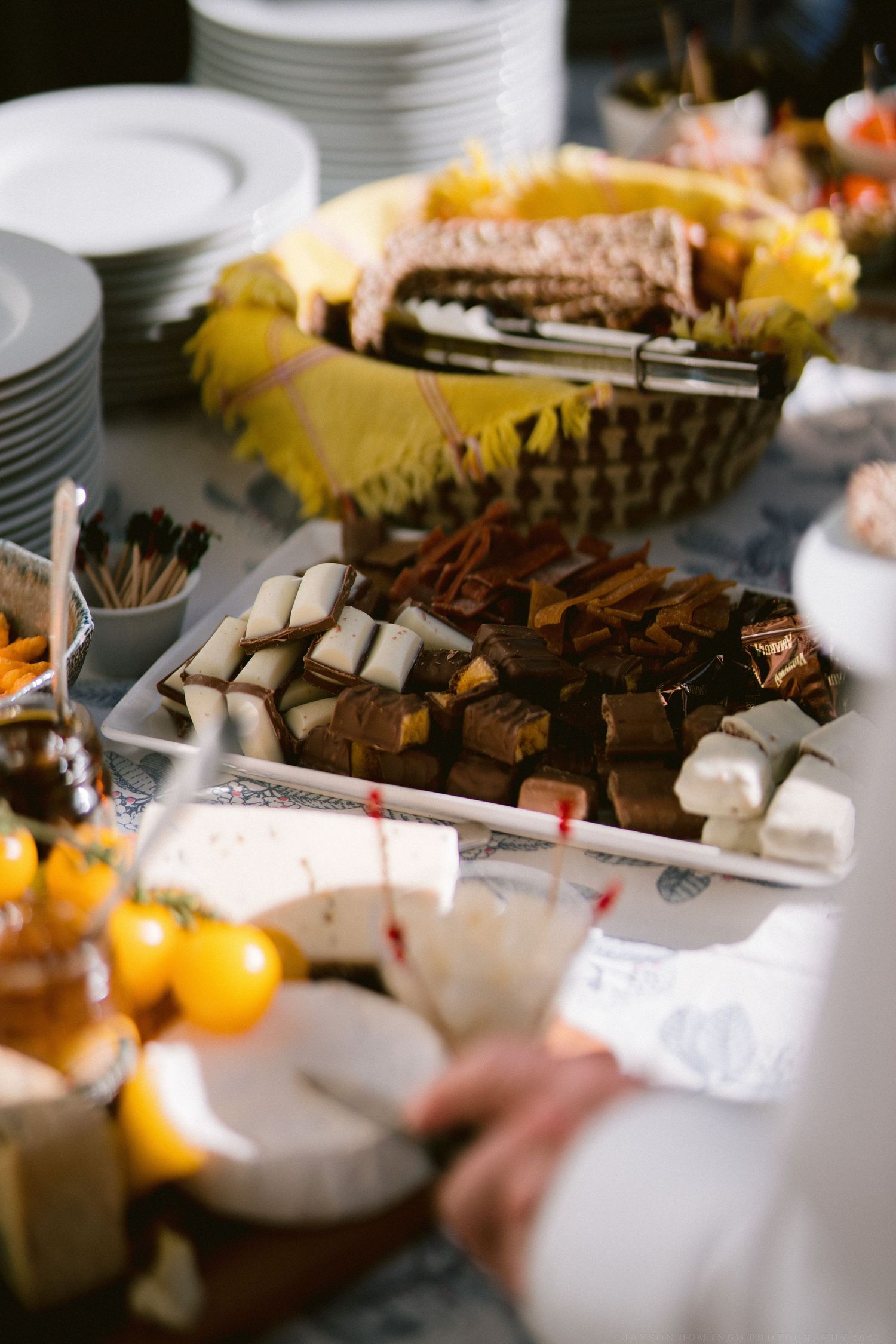 Dessert table with various chocolate treats and sweets displayed on white plates.