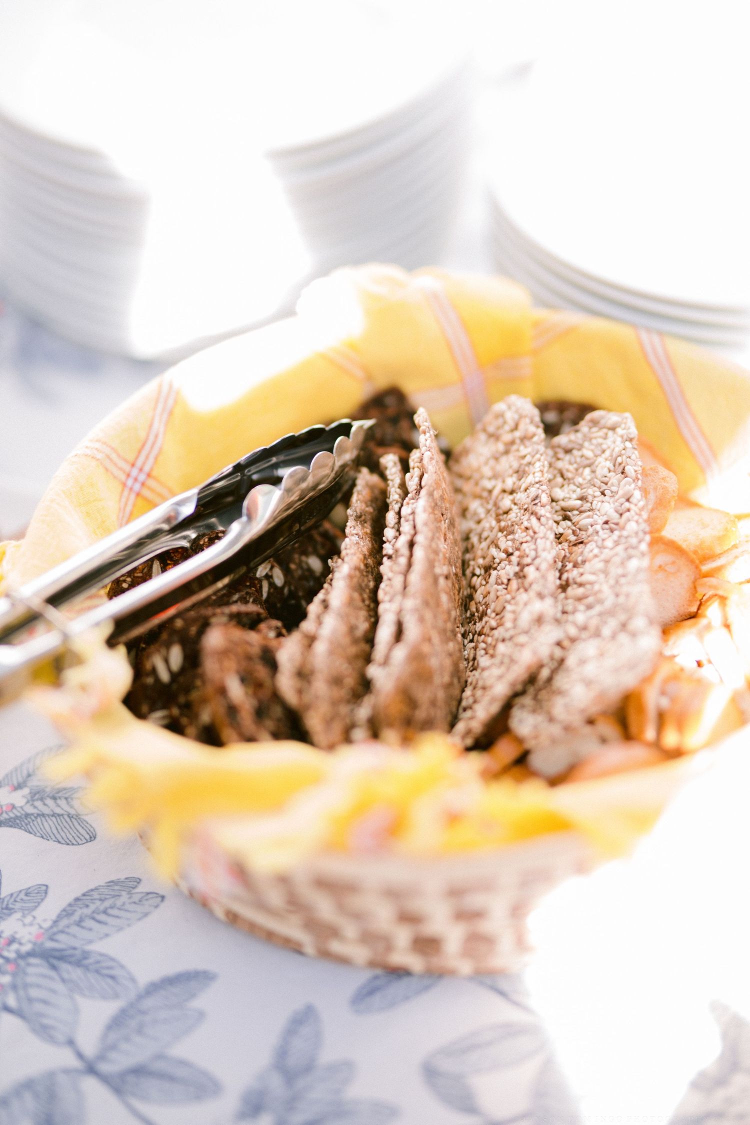 Sliced meat with seasonings served on a yellow napkin in a rustic basket setting.