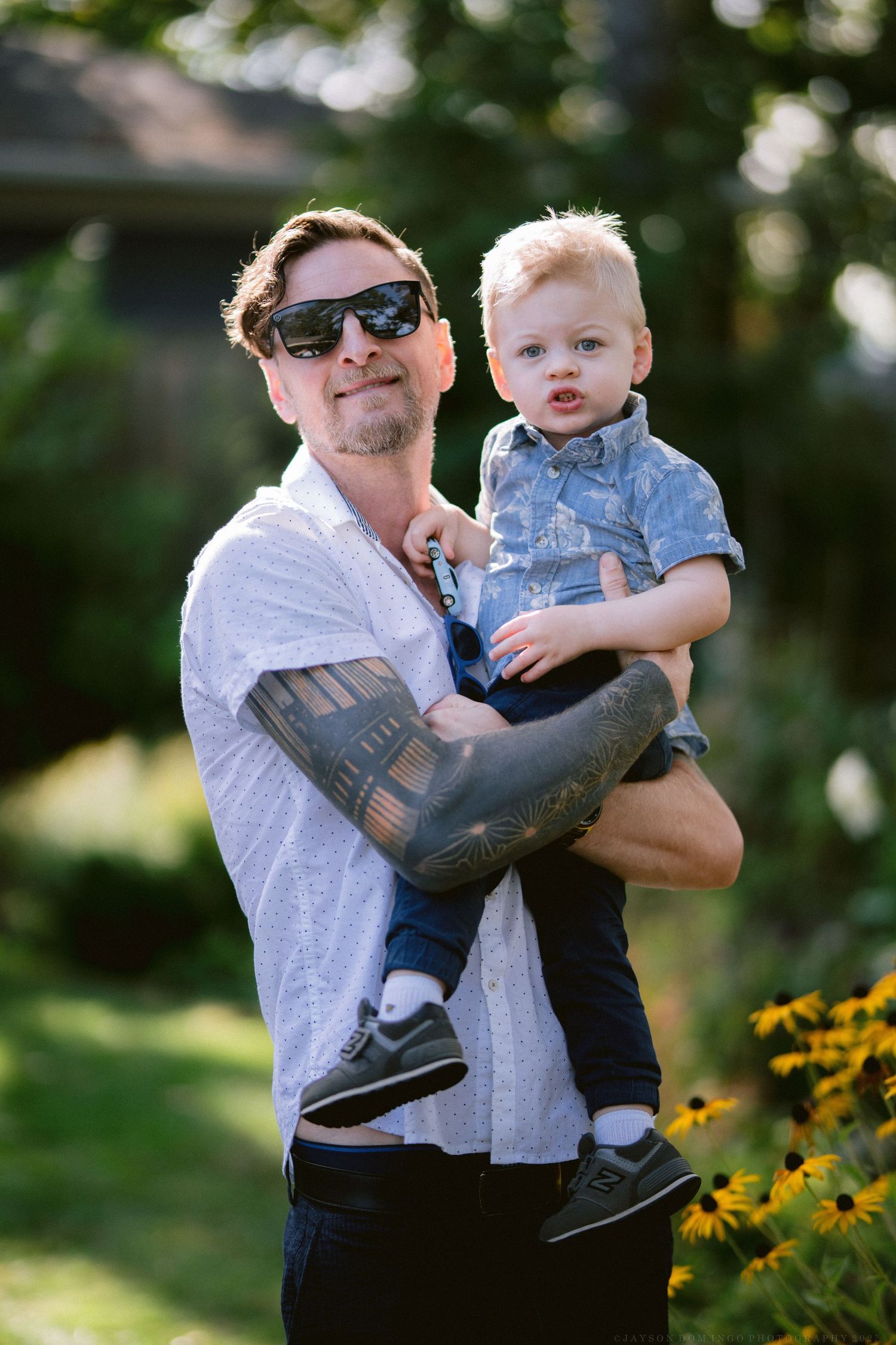 Parent and child share playful moments in a garden with yellow flowers.