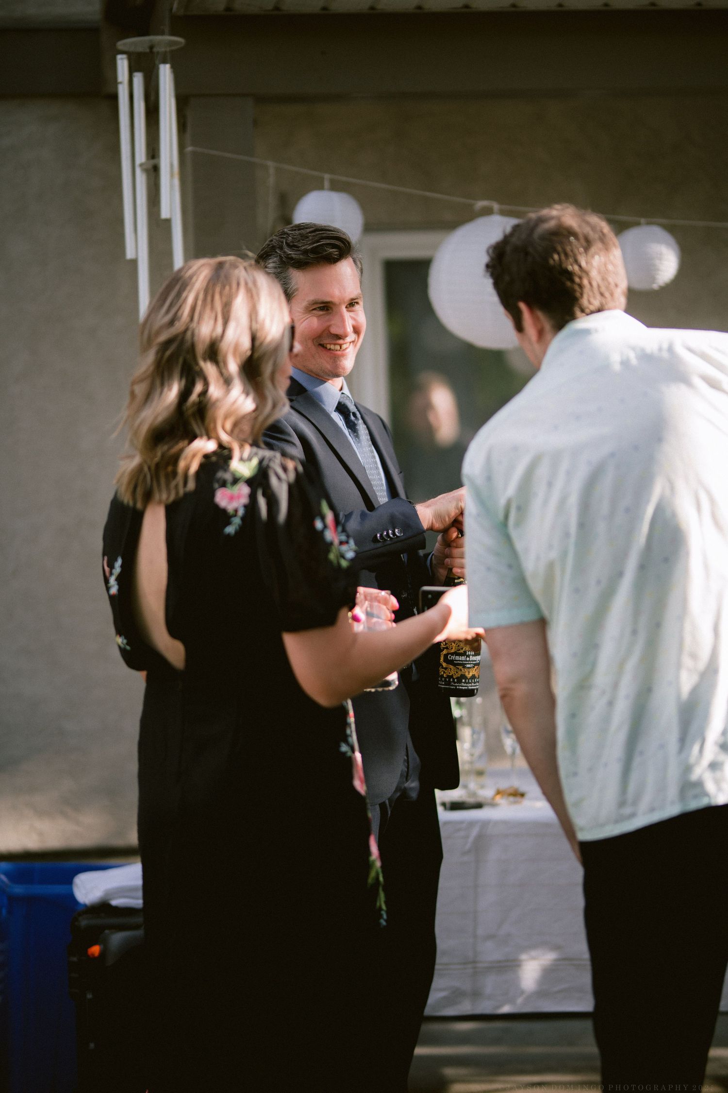 People in formal attire mingle and socialize at an indoor event space.