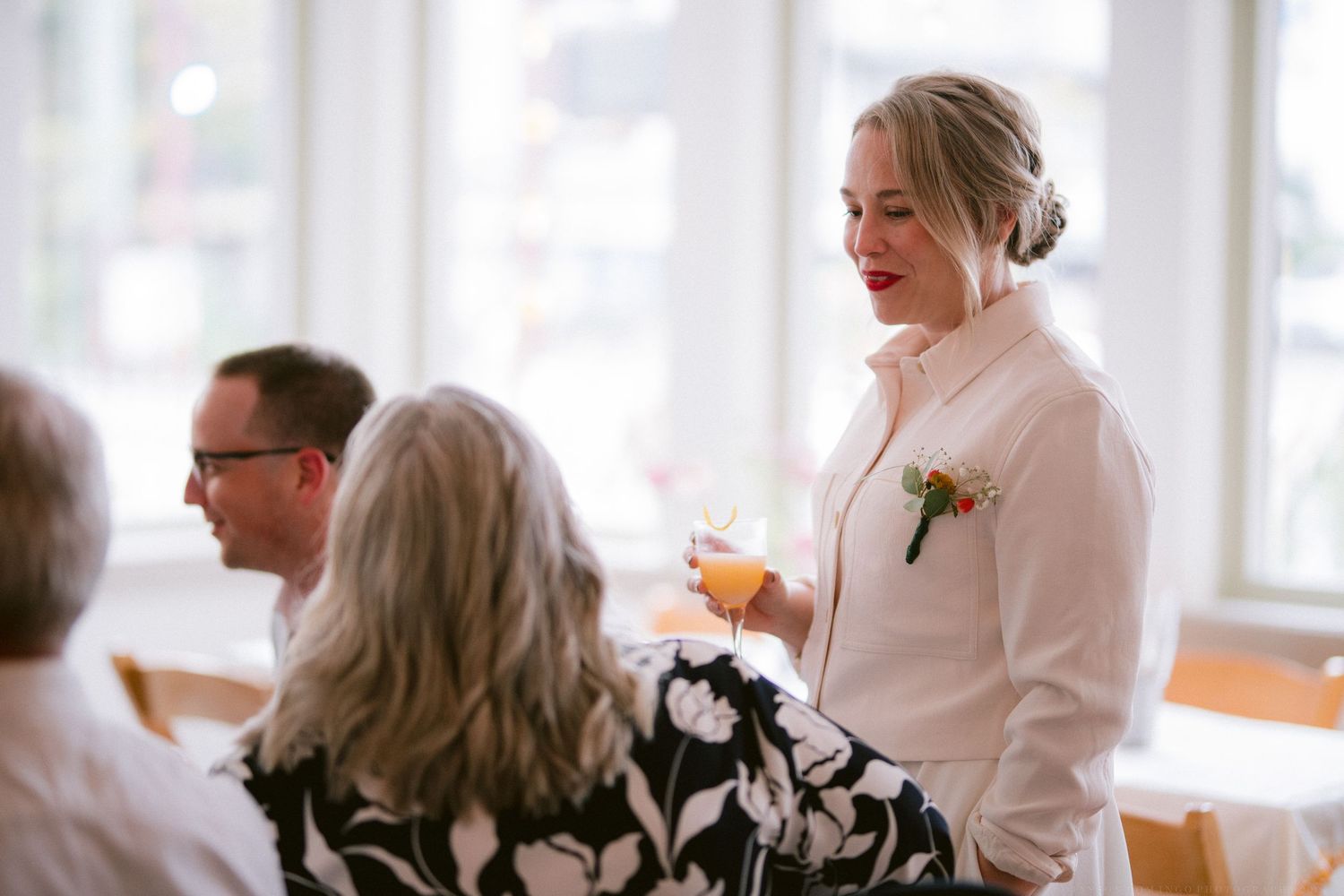 Candid moments captured during an indoor wedding reception with natural lighting.