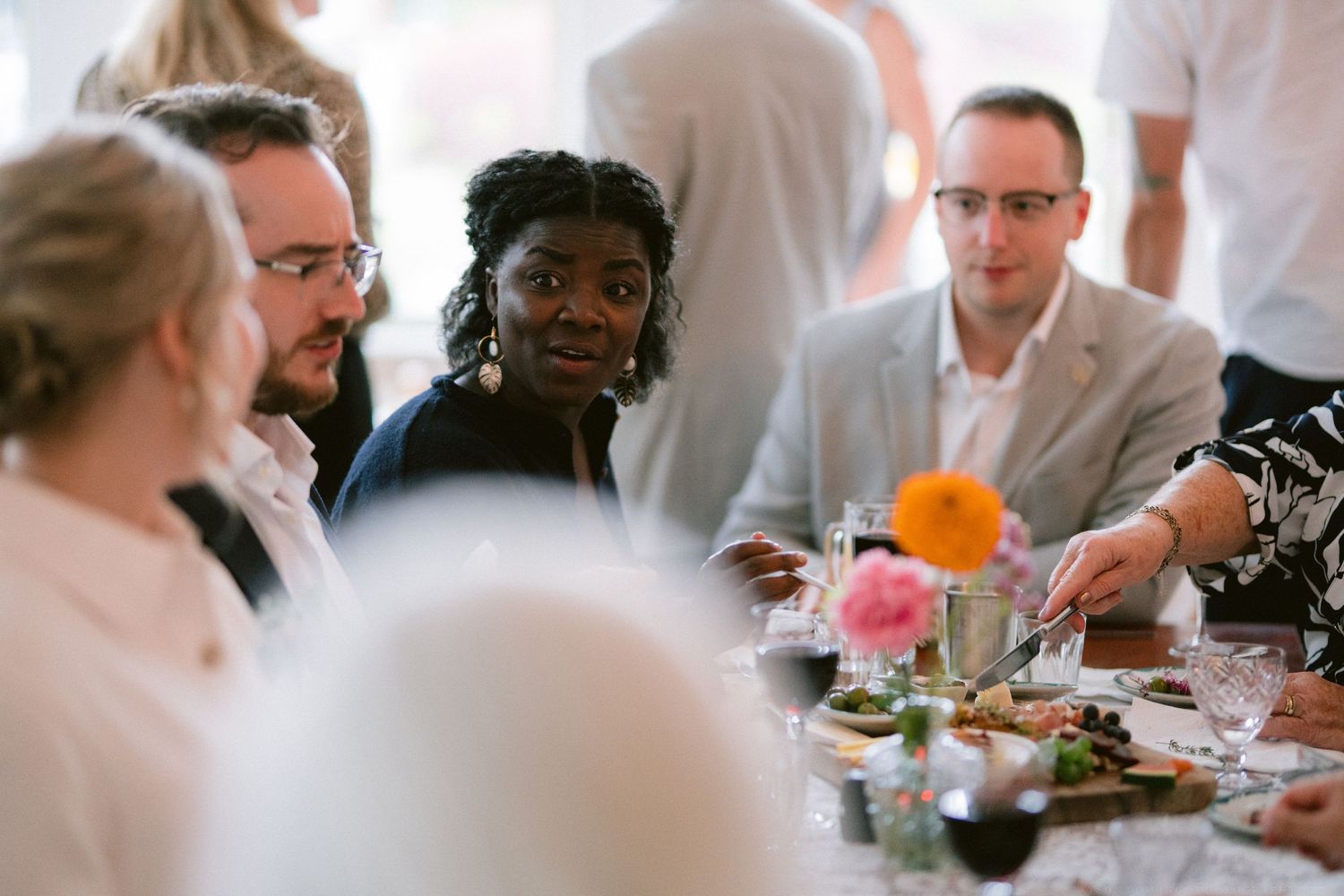 Wedding reception guests gathered around tables during an indoor celebration.
