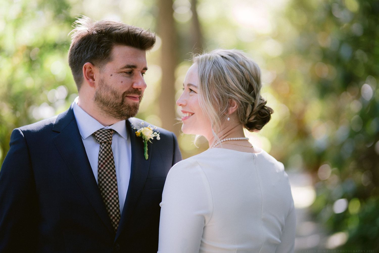 Romantic wedding couple shares intimate moments in an outdoor garden setting with natural lighting.