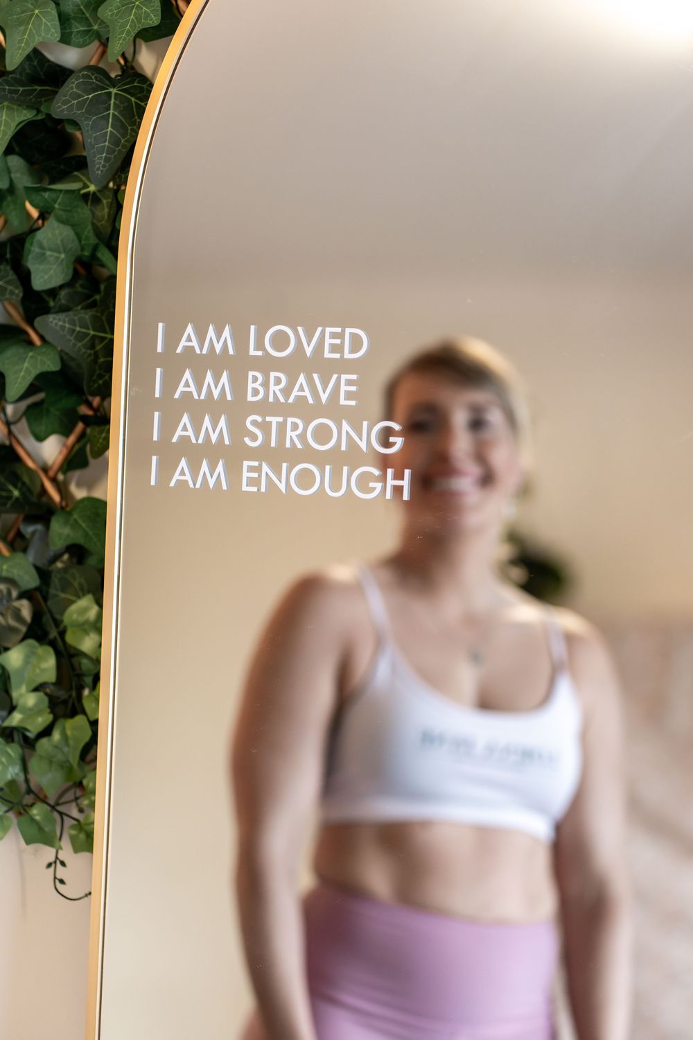 Inspirational text overlays reading 'I AM LOVED, I AM BRAVE, I AM STRONG, I AM ENOUGH' on workout photos.