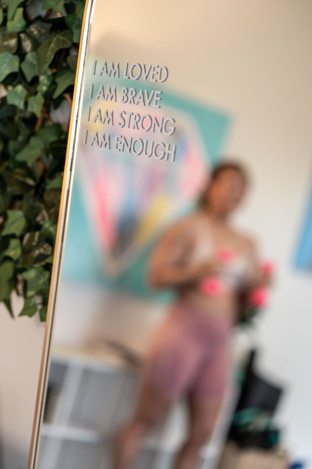 Motivational text reading 'I am strong' and 'I am brave' displayed on studio wall with plants.