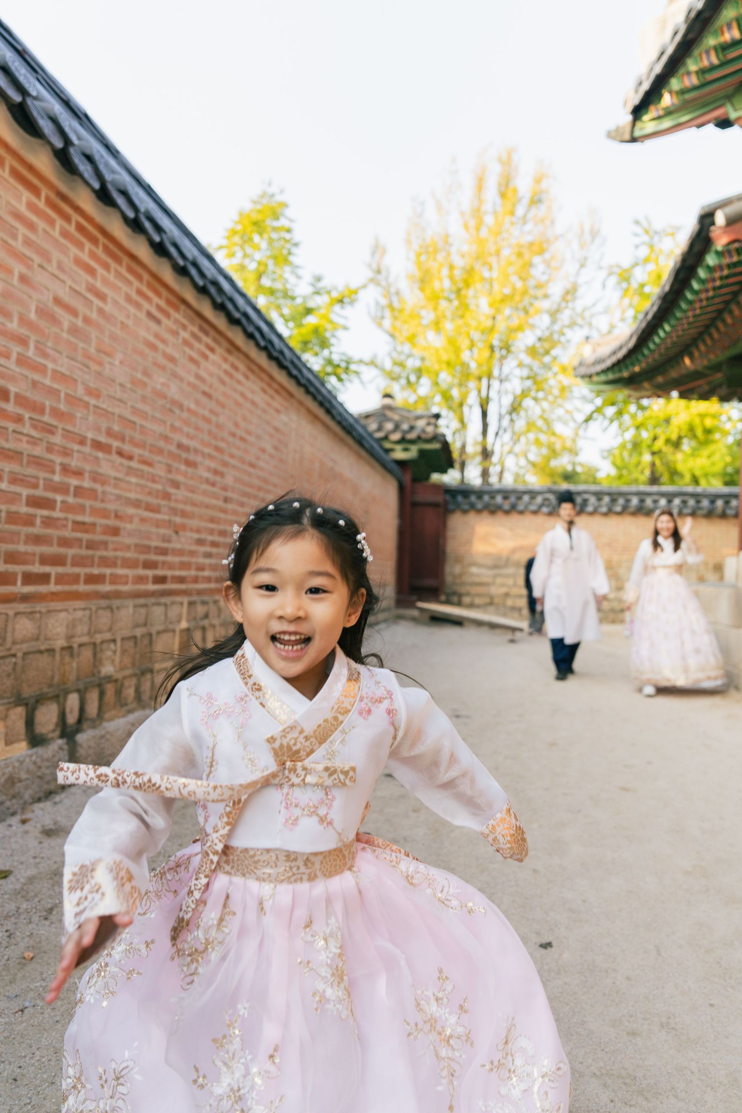Traditional Korean hanbok dress flows gracefully as figure moves through historic palace courtyard.