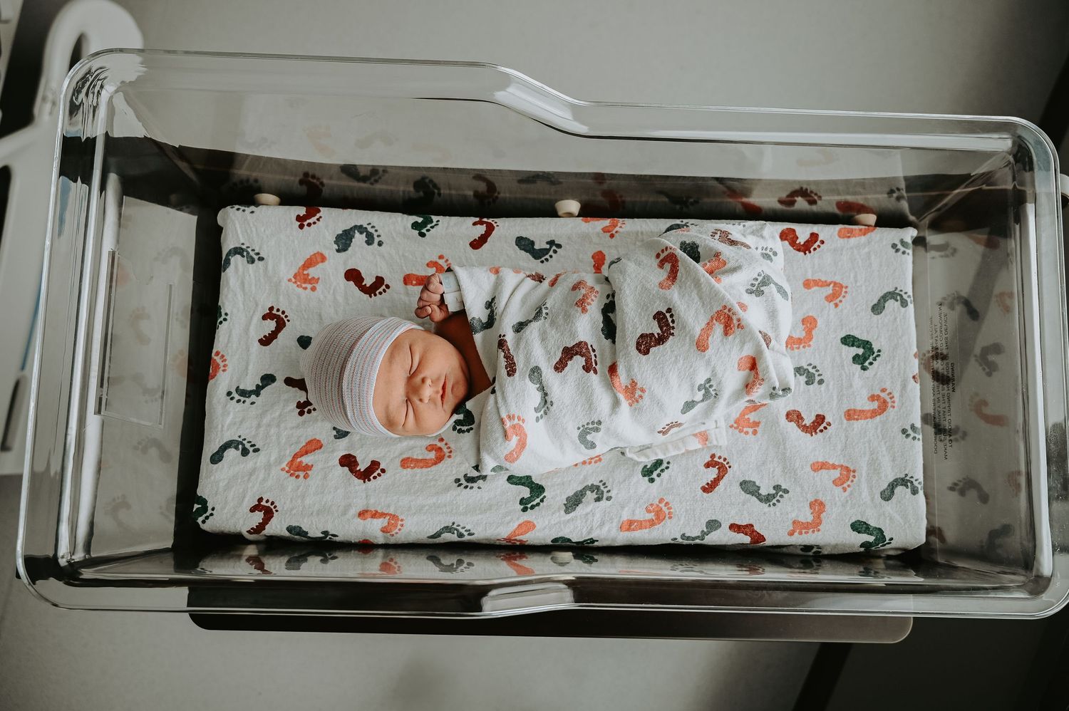 Hospital bassinet with floral patterned bedding viewed from above.