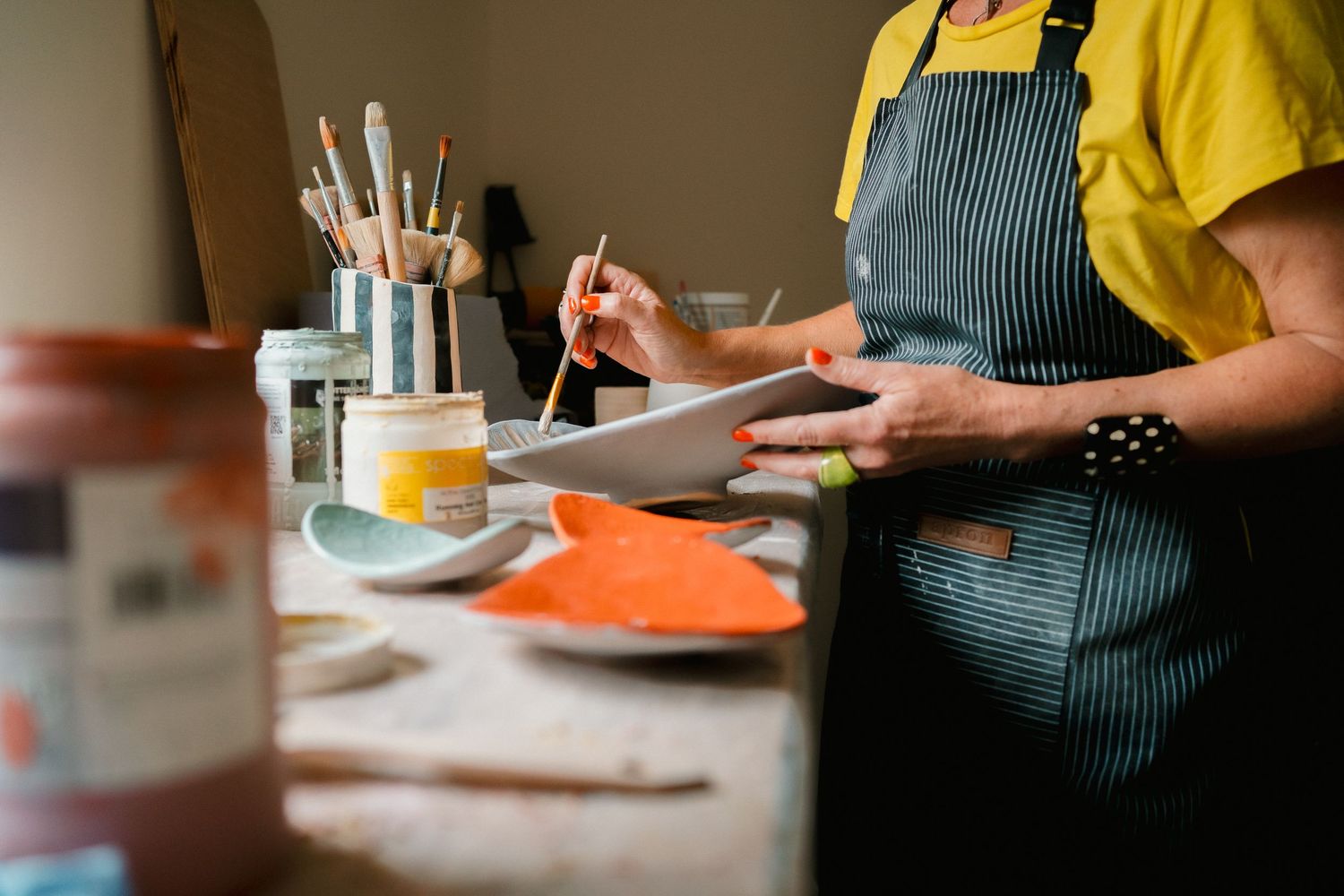 Close-up of hands preparing food on wooden cutting boards in a professional kitchen setting.
