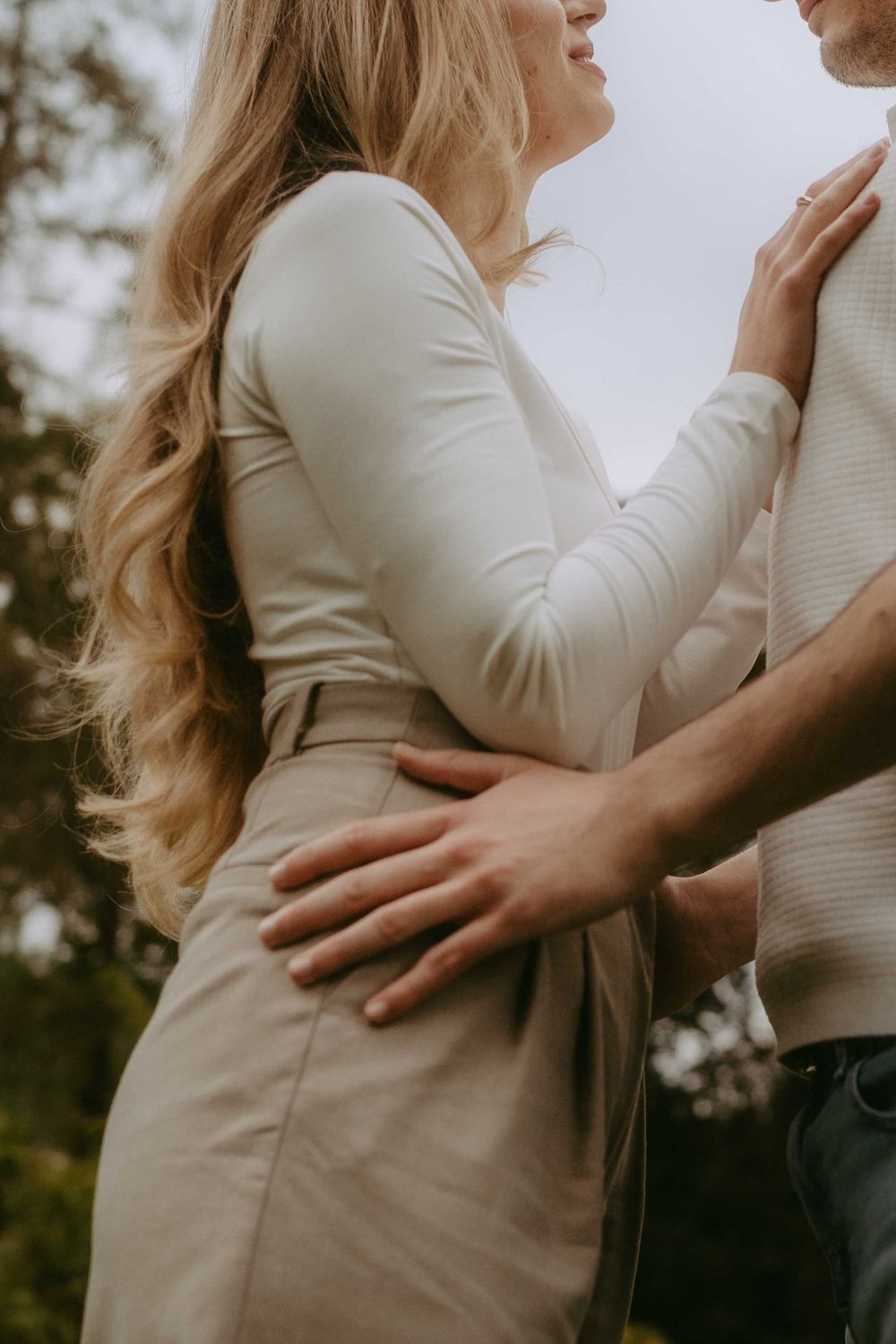 Intimate close-up portrait showing tender embrace in neutral toned clothing.