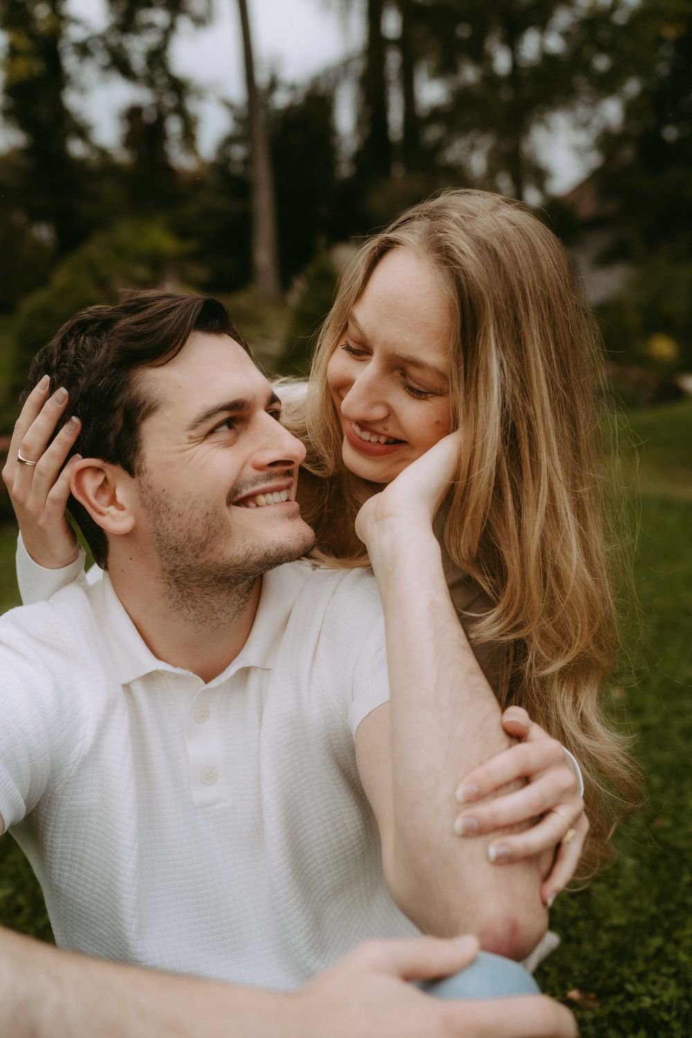 Couple in white tops share intimate close-up moments outdoors.