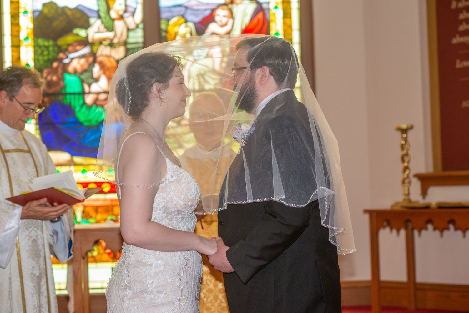 A church wedding ceremony shows a couple exchanging vows at the altar with stained glass windows in the background.