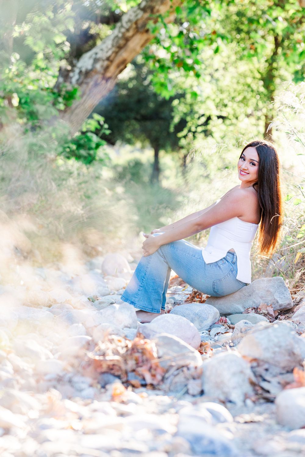 Simi Valley photographer captures Ashlyn in a playful outdoor portrait session at Challenger Park with trees and riverbed backdrops.