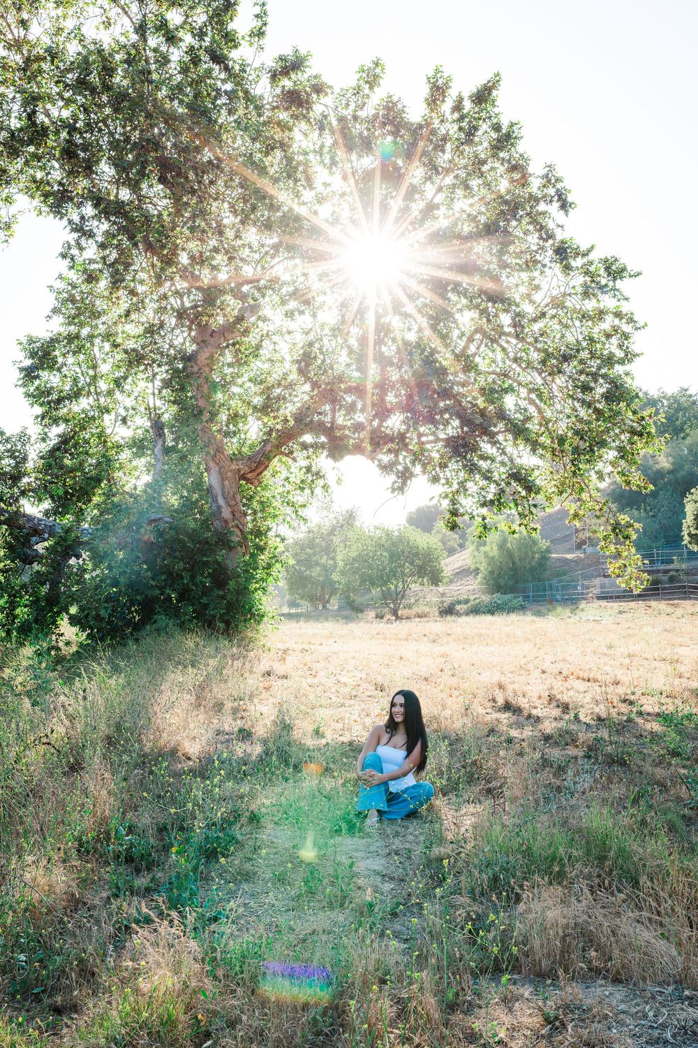 Simi Valley photographer captures Ashlyn in a playful outdoor portrait session at Challenger Park with trees and riverbed backdrops.