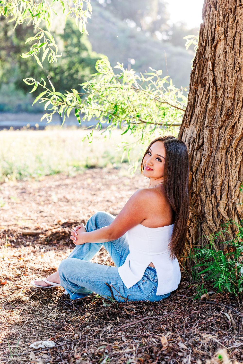 Simi Valley photographer captures Ashlyn in a playful outdoor portrait session at Challenger Park with trees and riverbed backdrops.
