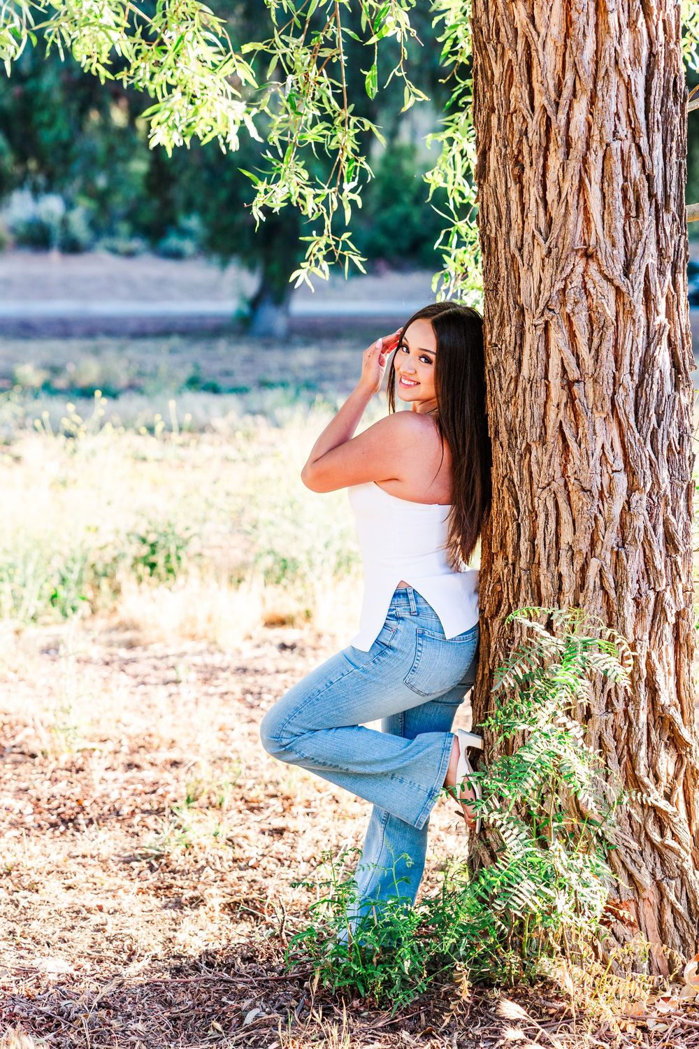 Simi Valley photographer captures Ashlyn in a playful outdoor portrait session at Challenger Park with trees and riverbed backdrops.