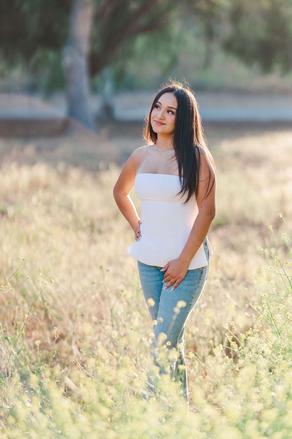 Simi Valley photographer captures Ashlyn in a playful outdoor portrait session at Challenger Park with trees and riverbed backdrops.