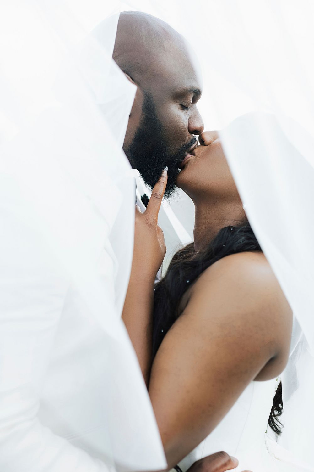Artistic black and white wedding portraits with flowing veil and dramatic angles.