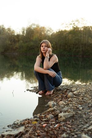 À Charleroi, portrait d’une femme assise au bord du lac d’une ancienne carrière lors d’une séance photo