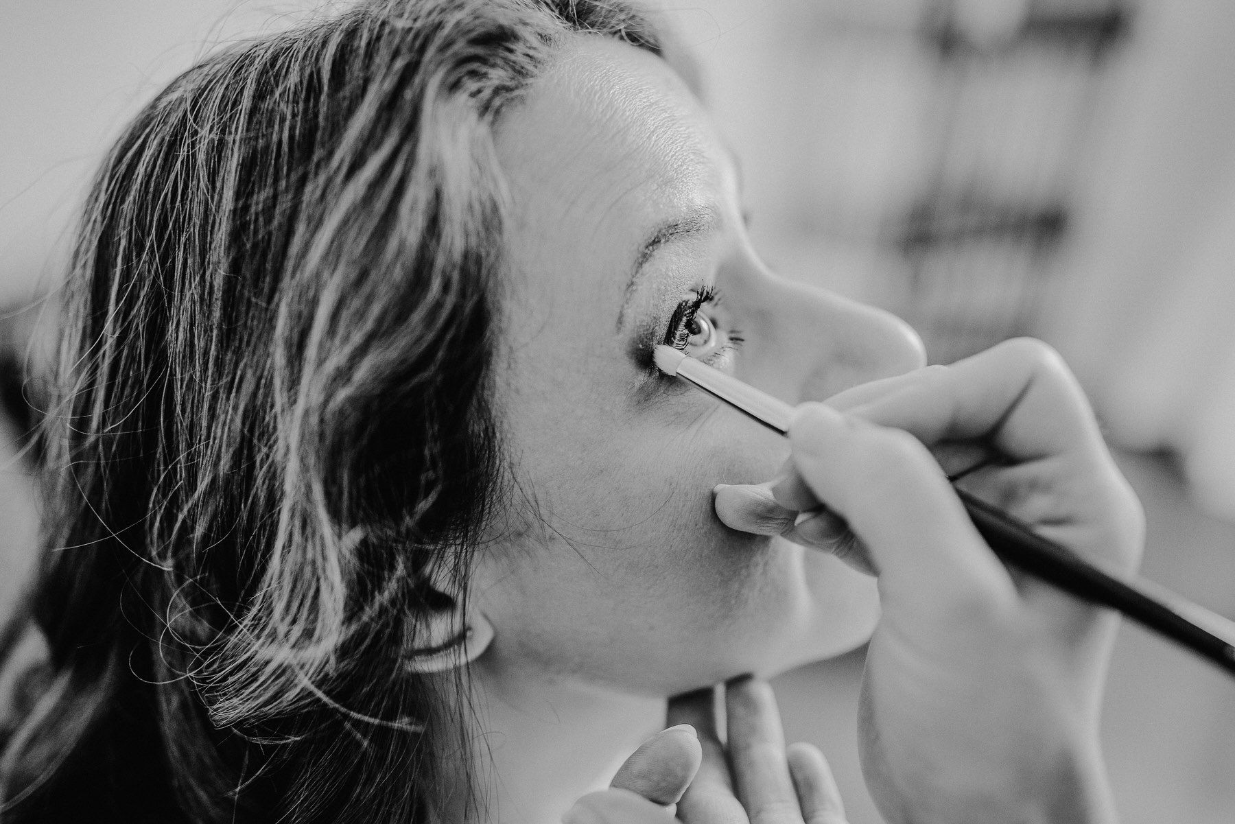 Nahaufnahme einer Schwarz-Weiß-Aufnahme der Make-up-Anwendung um die Augenfläche.